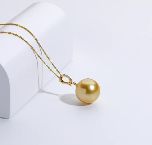 The South Sea Gold pearl with a 12-13mm,Round Sharp without flaws, set in a diamond accent pendant 18k clasp